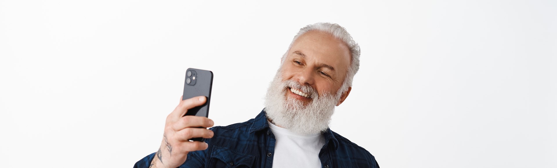 /media/tpojltng/happy-senior-man-taking-selfie-with-his-credit-card-smiling-as-paying-online-with-face-id-smartphone-app-shopping-internet-shop-standing-against-white-wall.jpg
